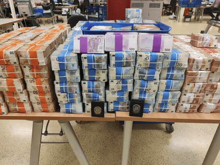 Bundles of euros neatly packaged and displayed on a table by police who had seized the cash from drug gangs.