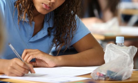A pupil using a black pen in an exam