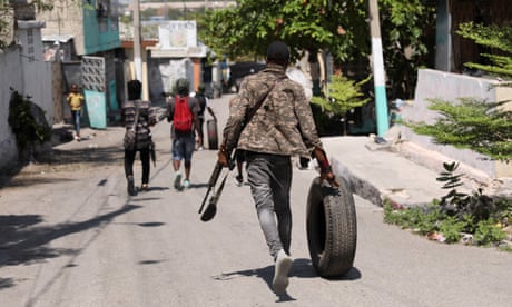 Um membro de uma gangue caminha por Porto Príncipe, Haiti, em 11 de março de 2024.