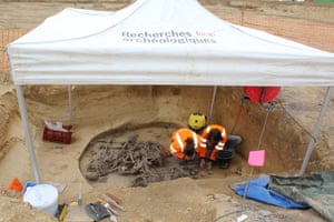 Researchers examine human remains at the massacre site.