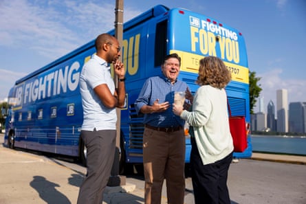 JB Pritzker laughs alongside two people