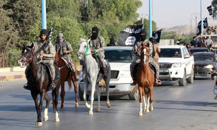 Isis fighters parade through Raqqa after its capture in June 2014.