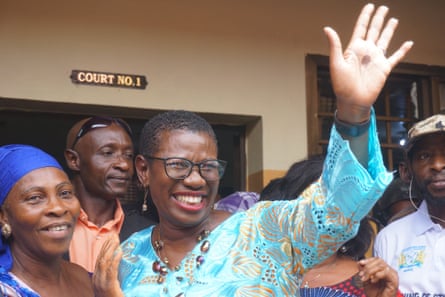 Freetown’s mayor, Yvonne Aki-Sawyerr, flanked by two other women, waves outside a courtroom 