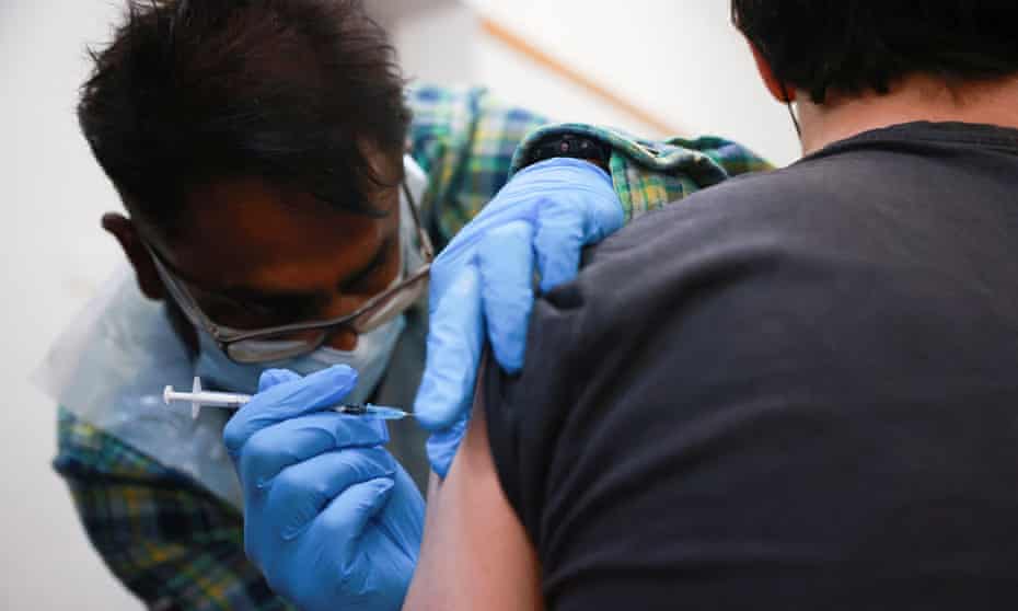 A health worker administers a Covid vaccine