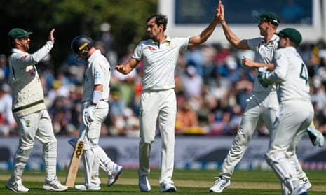 Mitchell Starc is congratulated for the early wicket of New Zealand's Will Young on day two.