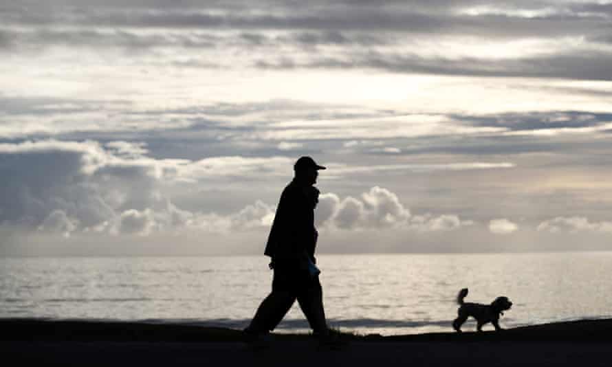 People put for a walk on Orewa Beach in Auckland