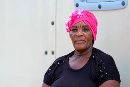 a woman in a pink hat stands outside a low building