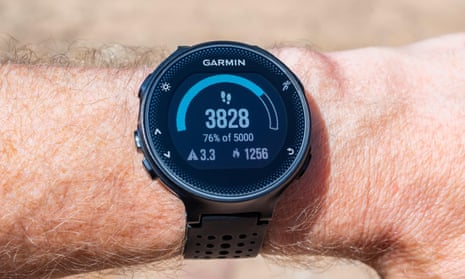 Garmin Smart Watch on male wrist displaying a step counter, distance traveled in kilometers and amount of calories burned