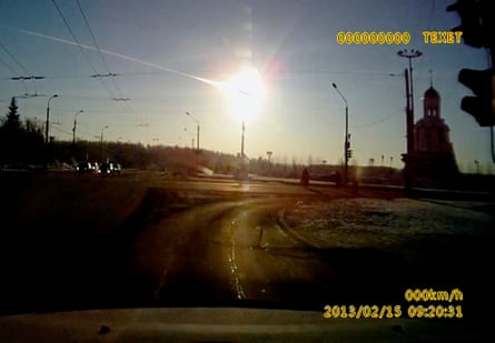 A huge ball of light in the sky above an urban streetscape