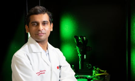 Eureka science prizes: Justin Yerbury wins analysis honour for work on motor neurone illness | Australia information 1 Sumeet Walia is posing for a photo in a lab. He is wearing a lab coat and the lab behind him is dark with a green glow