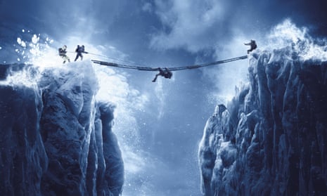 A rope suspended between two mountain peaks with someone crawling along it and others at either end