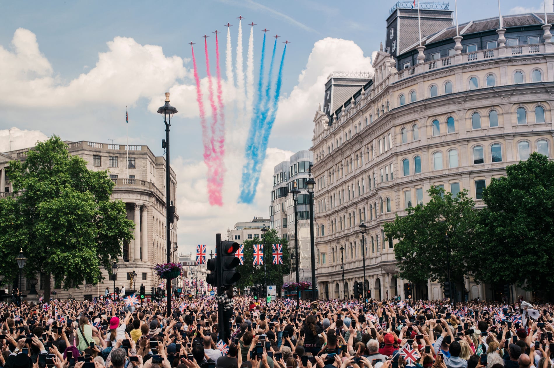 The Red Arrows fly past Trafalgar Square leaving red, white, and blue vapour trails