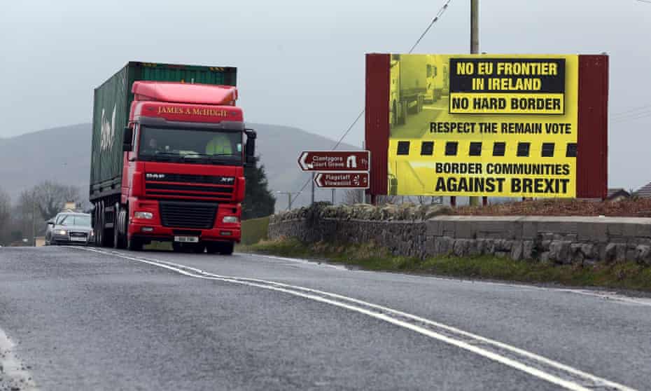 Trafic crosses the border into Northern Ireland from the Irish Republic next to a poster protesting against a hard Brexit near Dundalk. 