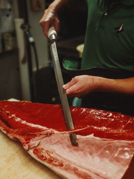 Tuna being carved by someone wielding a 2ft-long knife
