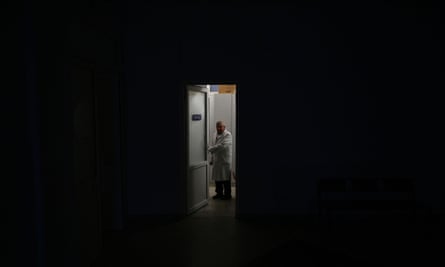A hospital employee stands at the doorstep of a maternity ward during a blackout after Russian attacks in the western Ukrainian city of Lviv
