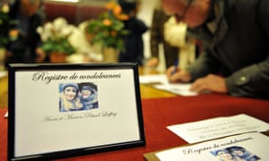 People sign a book of condolences during a commemoration ceremony at the city hall in Chailles, near Blois, central France, on November 17, 2015, to pay tribute to Anna and Marion Petard-Lieffrig, victims of the attacks.
