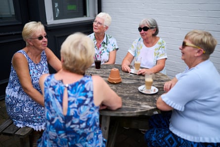 A group of women sitting around a table with coffees