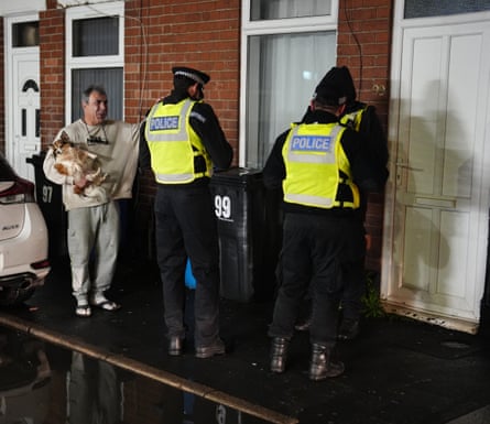 Police officers directing residents to evacuate the street