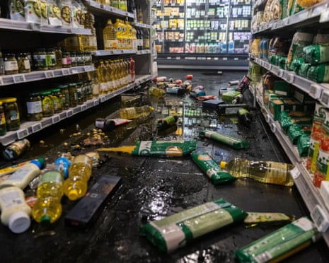 Looted Paris supermarket aisle floor covered in spilled oil and scattered broken goods