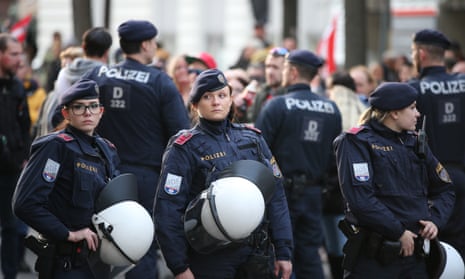 Austrian police officers stand guard as people gather in Vienna to protest against Covid restrictions.