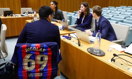 A fan sits on a chair with a Barcelona shirt draped over the back at the European court of justice