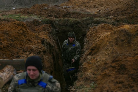 Ukrainian soldiers walking along a trench