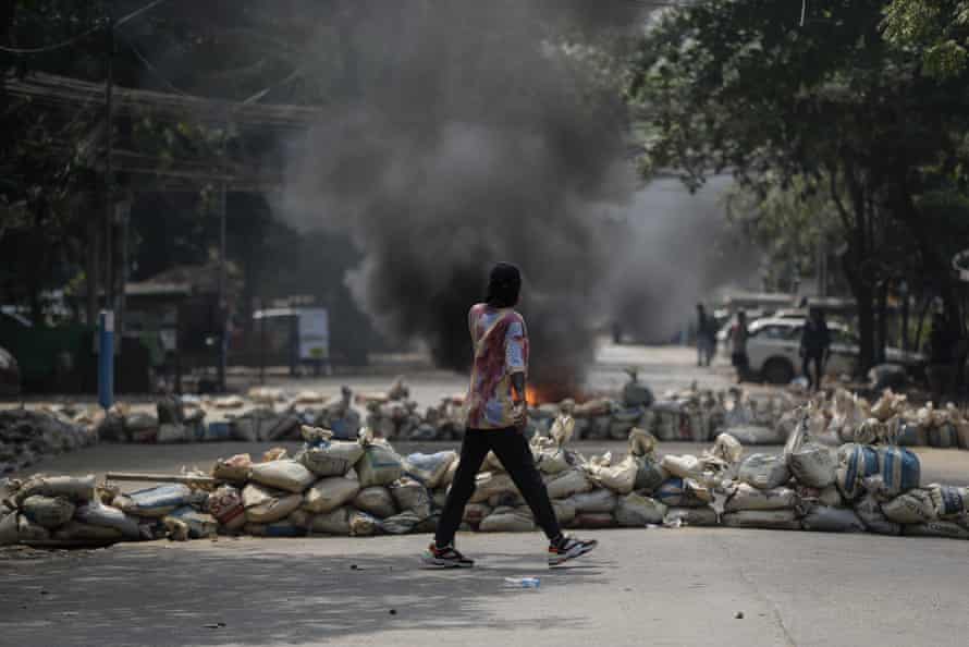 A demonstrator in front of a barricade during protests against the military coup in Yangon on Saturday, 27 March.