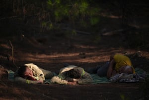 Firefighters sleeping on a blanket on the ground