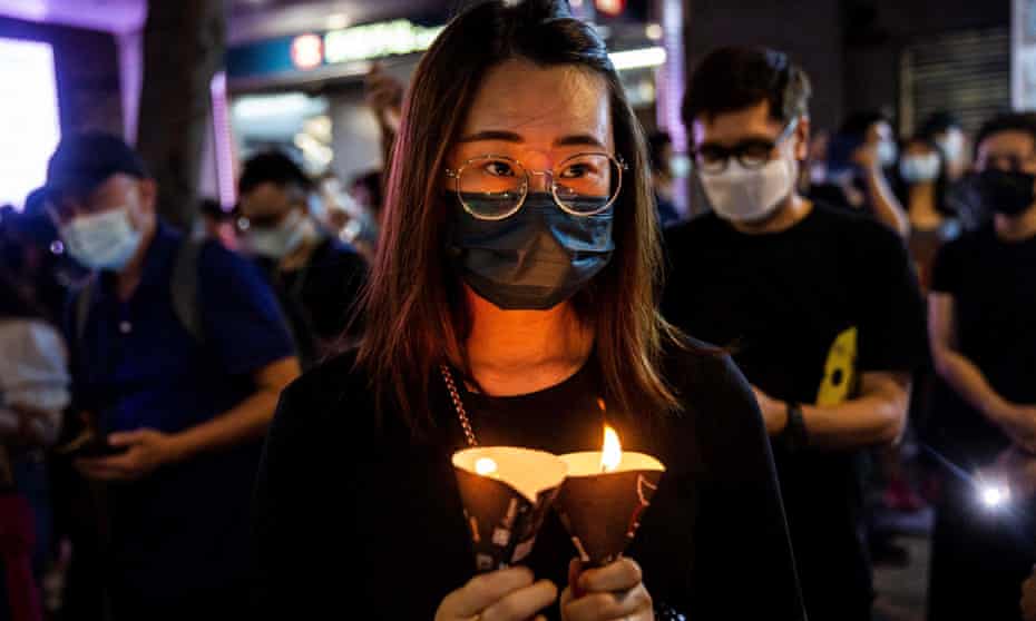 A woman holding candles in the Causeway Bay district of Hong Kong a year ago after police closed a venue where people traditionally gather to mourn the victims of China’s 1989 Tiananmen Square crackdown