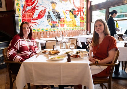 Emma and Alys sitting at a restaurant table, smiling at the camera