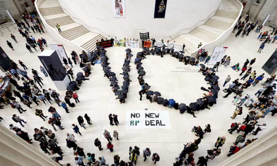 Protesters with umbrellas from word 'NO' on floor of museum