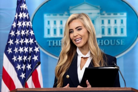 Zacharia smiles at a lectern with a US flag in the background