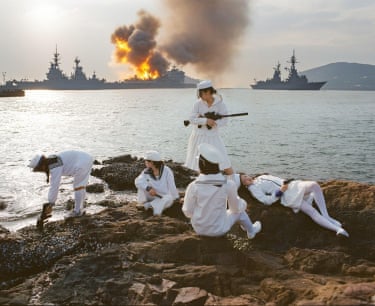 Lean Lui – White BarracksLui is an artist and photographer based in Hong Kong. The White Barracks is the third work in Lui’s Girl’s Universe series, focusing on the fractures within power structures. Here, Lui imagines a fictional island inhabited by a battalion of girl cadets engaged in constant military drills. The naval uniforms worn by the girls symbolise discipline and authority and are closely tied to the iconography of imperialism.