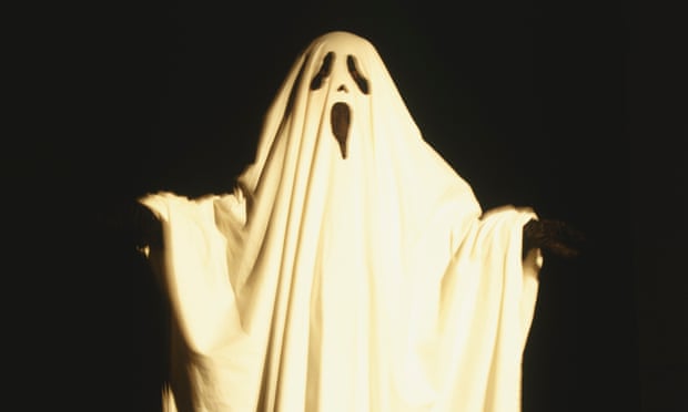 Child dressed up as ghost draped with white sheet that has facial features cut out, extending arms to the sides, front view.