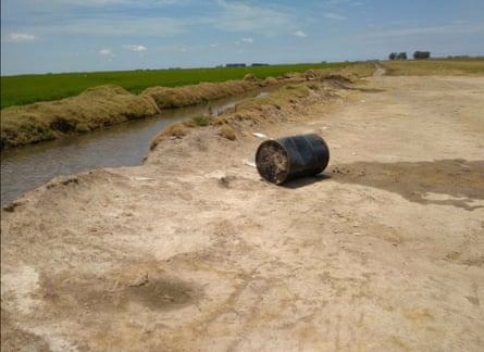 A discarded metal container on a river bank