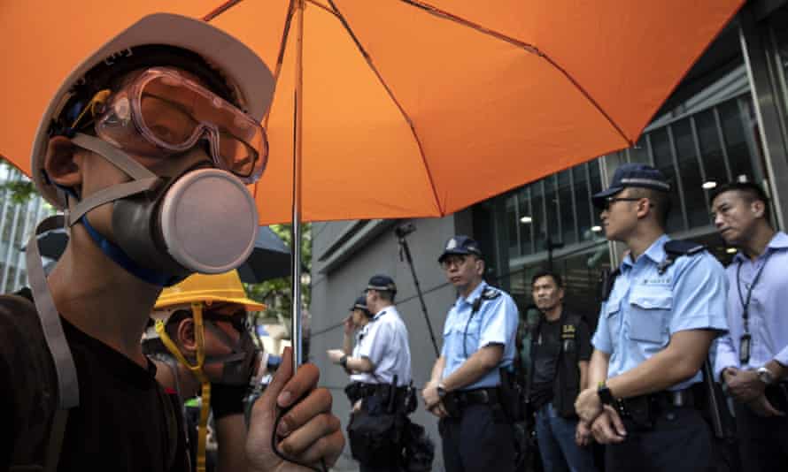 man with umbrella and gas mask and police