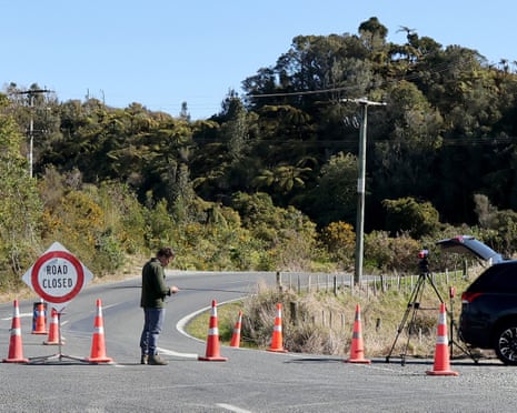 A cameraman stands at a roadblock near Piopio