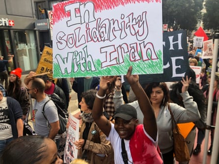 people march, with brown holding up a sign that says ‘in solidarity with iran’