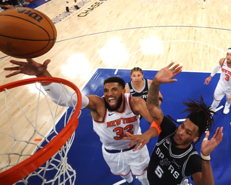 Karl-Anthony Towns jumps to tip the ball into the basket.