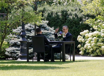 Keir Starmer and Volodymyr Zelenskyy sit at a table in the shade of Kyiv’s presidential palace gardens.