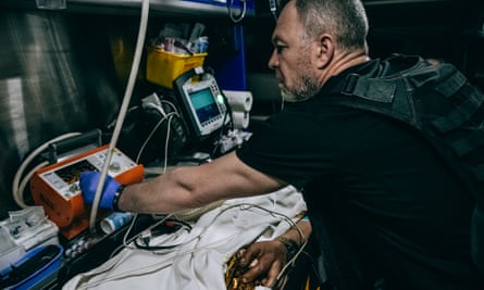 A Ukrainian medic treats a critically ill soldier in a Toyota Land Cruiser SUV