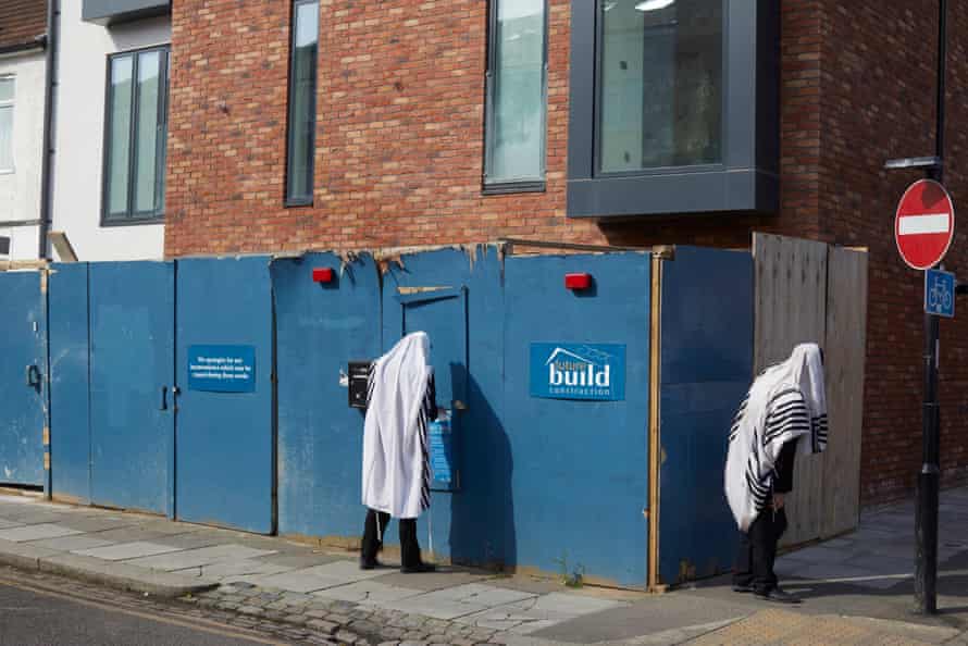 7 May: Because all synagogues are closed, members of the tight-knit Jewish community of Stamford Hill come together in their front gardens and on the roadside so that they could form the minyan required for daily prayer.