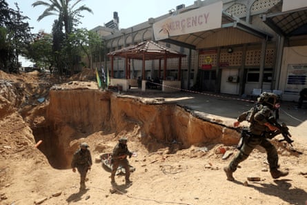 Israeli soldiers walk out from a tunnel emerging in front of a hospital