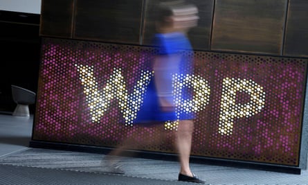 woman walks past WPP sign
