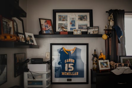 Picture frames and trinkets sit on a shelf in a dimly lit room.