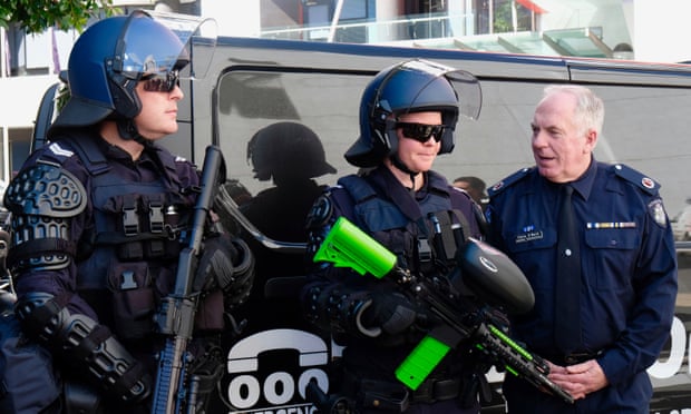 Luke Henriques-Gomes/The Guardian Victorian police assistant commissioner Chris O’Neill (right) and two public order response officers show new non-lethal weapons the police force say are required to combat violent protests.