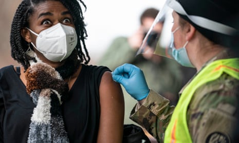 A woman prepares to receive a coronavirus vaccine from a member of the national guard in Bowie, Maryland, on Saturday.