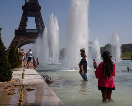 People cool off with water from Varsovie fountain by the Eiffel Tower during a heatwave in Paris, France.