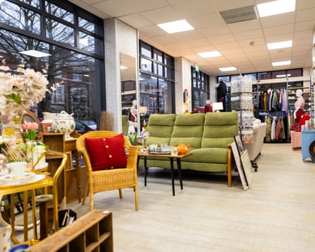 A wide shot of a clean and organised charity shop filled with donated items, including ceramics and homeware. There are no people present.