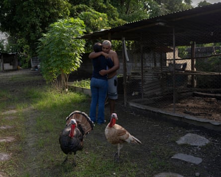Adolfo Guedez hugs a niece in the backyard of his house